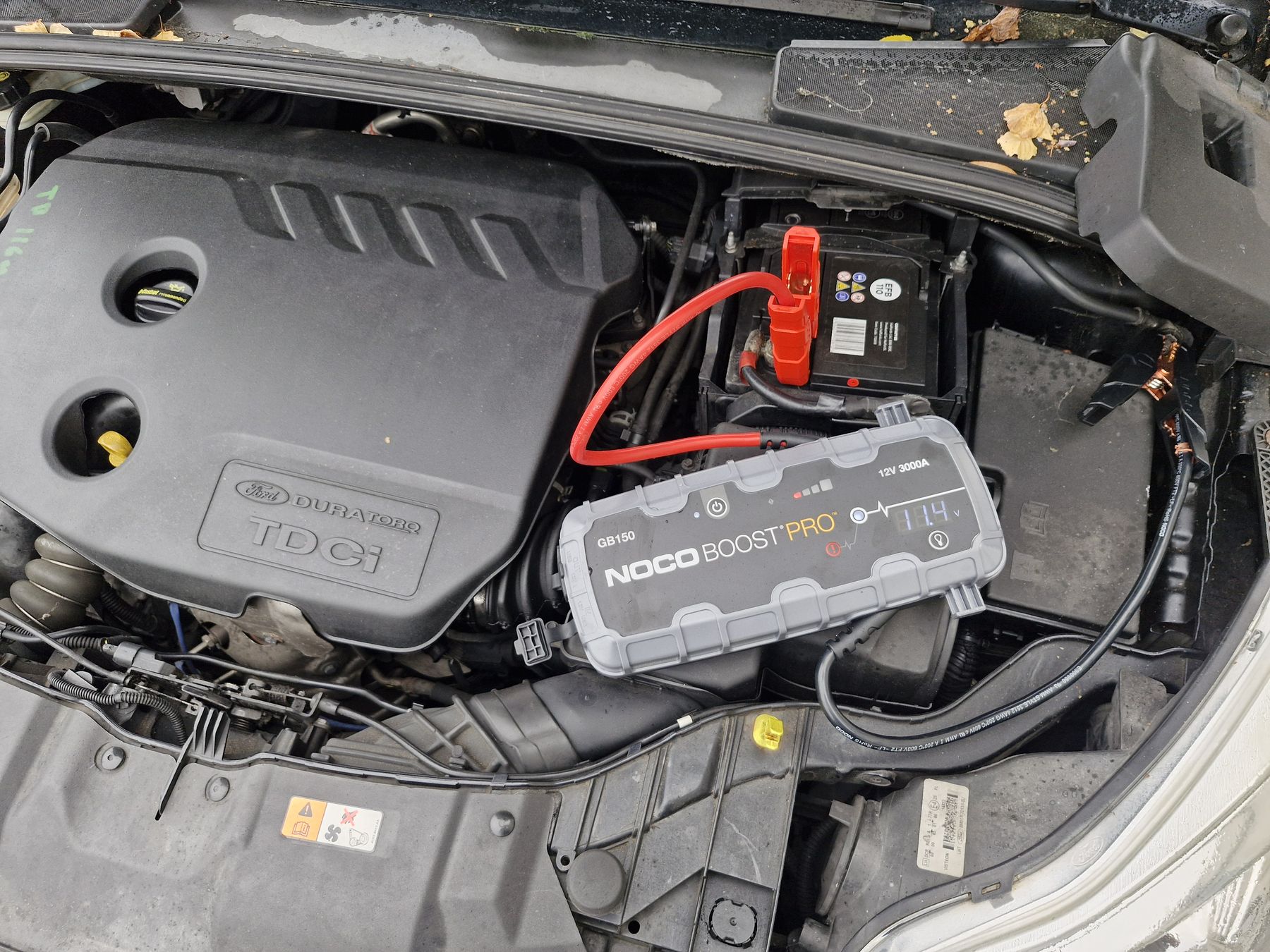 NOCO Boost Pro jump starter connected to a Ford Duratorq TDCi diesel battery, display reading 11.4V